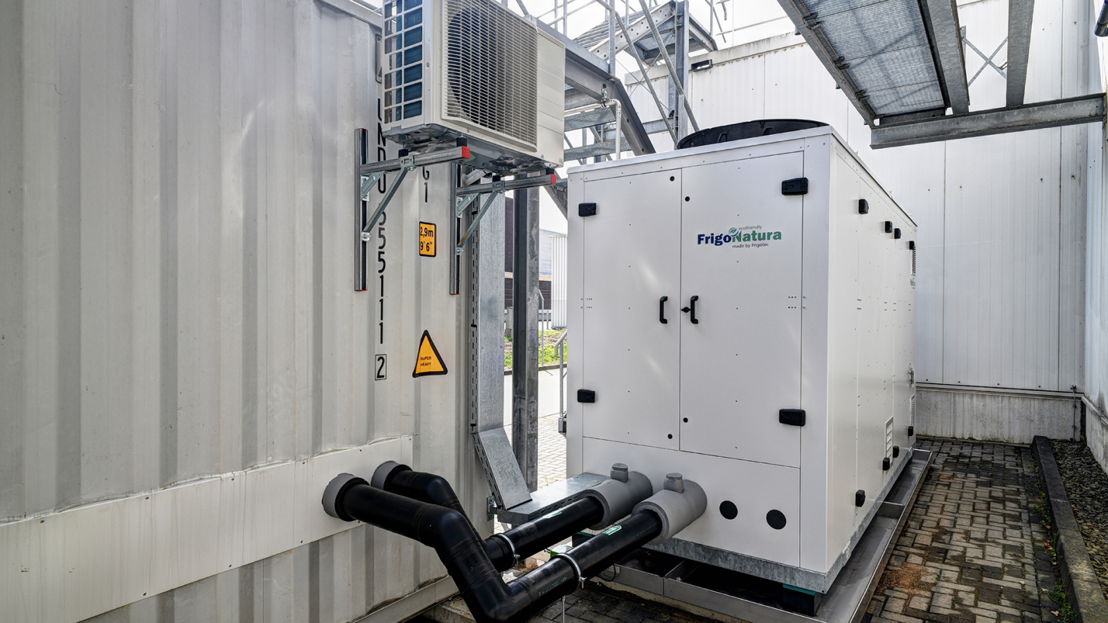 Liquid chiller in front of the building with container next to it.