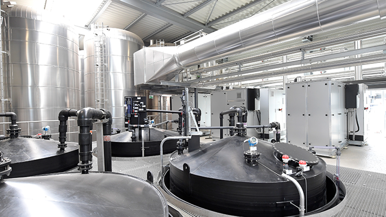 High-temperature heat pumps HP 1, 2 and 3 in the sewage treatment plant’s new machine room. Left in the image: Two of the eight heat accumulators, into which the heat pumps feed hot water at 90°C to operate the belt dryer