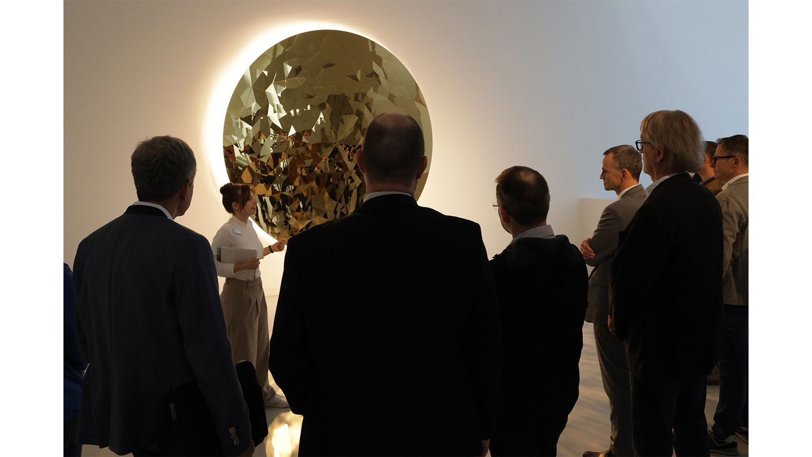 Teilnehmer der Veranstaltung vor einer beleuchteten Kunstinstallation