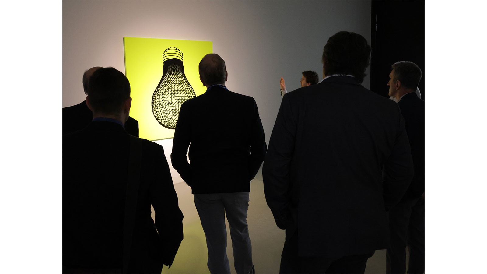 Teilnehmer der Veranstaltung vor einer beleuchteten Kunstinstallation